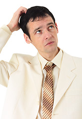 Image showing Puzzled man scratches his head, isolated on white