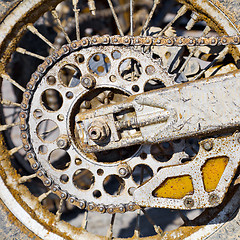 Image showing Rear wheel of motorcycle with chain covered with dirt