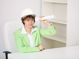 Image showing The woman - builder in helmet with a drawing in hands