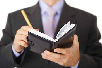 Image showing Businessman takes notes in notebook - closeup