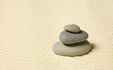 Image showing Pyramid of three stones on sand