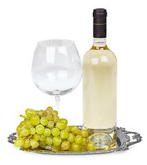 Image showing Bottle of white wine, glass and grapes on metal tray
