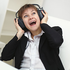 Image showing Cheerful woman with a big stereo headphones