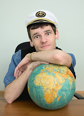Image showing Young man in a captain's cap with globe