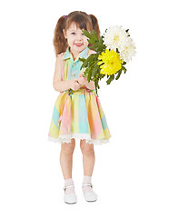 Image showing Cheerful child waving a bouquet of flowers