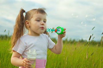 Image showing Little girl starts soap bubbles