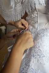 Image showing To the bride fasten a wedding dress
