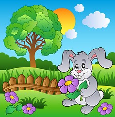 Image showing Meadow with bunny holding flower