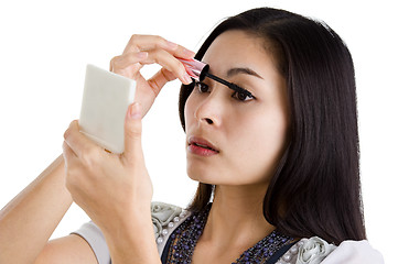 Image showing young woman putting on black mascara 