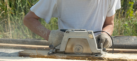 Image showing The man with a circular saw