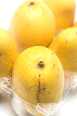 Image showing champagne mangos in plastic box white background