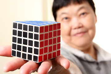 Image showing senior chinese woman show a complete  rubik cube