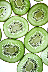 Image showing Detail view of kiwi slices backlighted over white background. 