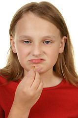 Image showing young girl taking a pill