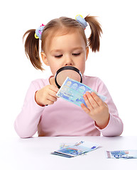 Image showing Girl is looking at euro banknote using magnifier