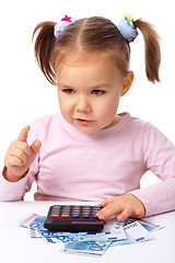 Image showing Little girl plays with money