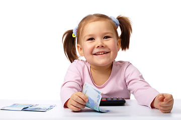 Image showing Little girl with few paper euro banknotes