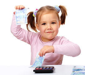 Image showing Little girl with few paper euro banknotes