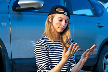 Image showing Young Blond Woman With Her Broken Car