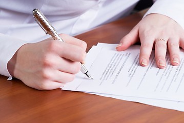 Image showing Businesswoman signing