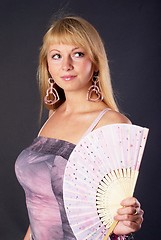 Image showing Beautiful young woman with fan