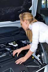 Image showing Young woman at broken car