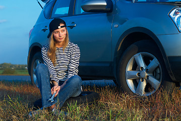 Image showing Young Blond Woman With Her Broken Car