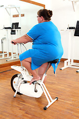 Image showing overweight woman exercising on bike