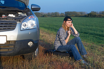 Image showing Young Blond Woman With Her Broken Car