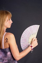 Image showing Beautiful young woman with fan