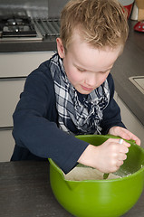 Image showing Boy making the dough for the cakes