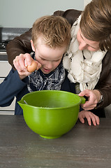 Image showing Boy and mother making the dough for the cakes