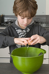 Image showing Boy making the dough for the cakes