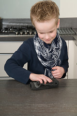 Image showing Boy cleaning the kitchen