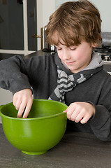 Image showing Boy making the dough for the cakes