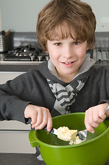 Image showing Boy making the dough for the cakes
