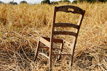 Image showing broken wood chair in the dry grass field