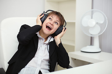 Image showing Emotional woman listening to music with big headphones