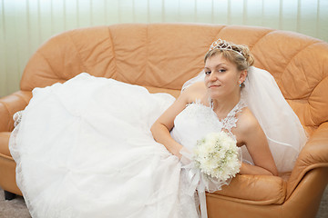Image showing Bride comfortably lies on big leather sofa
