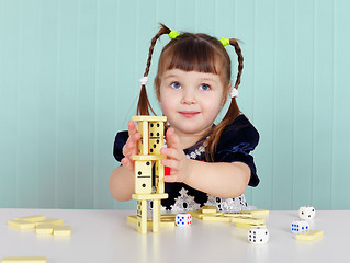 Image showing Child playing with small toys at table