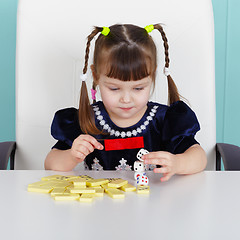 Image showing Little girl playing with toys, sitting at table
