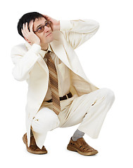 Image showing Scared young man in white suit sits