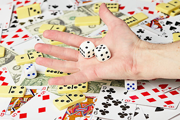 Image showing Dice on palm on the background cards and money