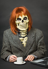 Image showing Horrible man - skeleton with red hair drinking coffee