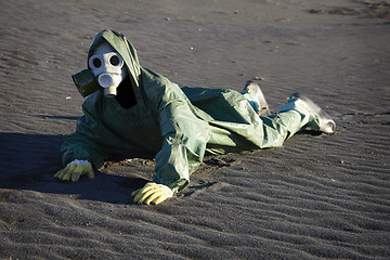 Image showing Man in gas-mask on desert ground