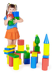 Image showing Happy child builds a castle out of blocks