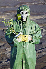 Image showing Scientific Environmentalist gently hugs a plant