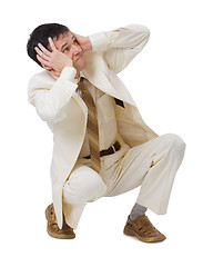 Image showing Frightened young man sits on white