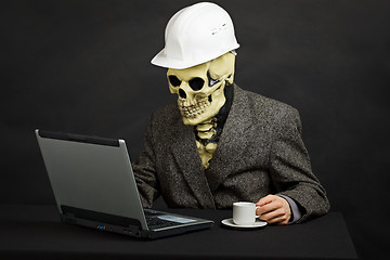 Image showing Comical man in helmet and skeleton mask with computer