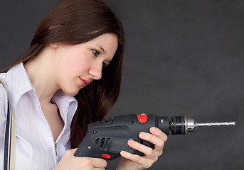 Image showing Female student learns to use a drill